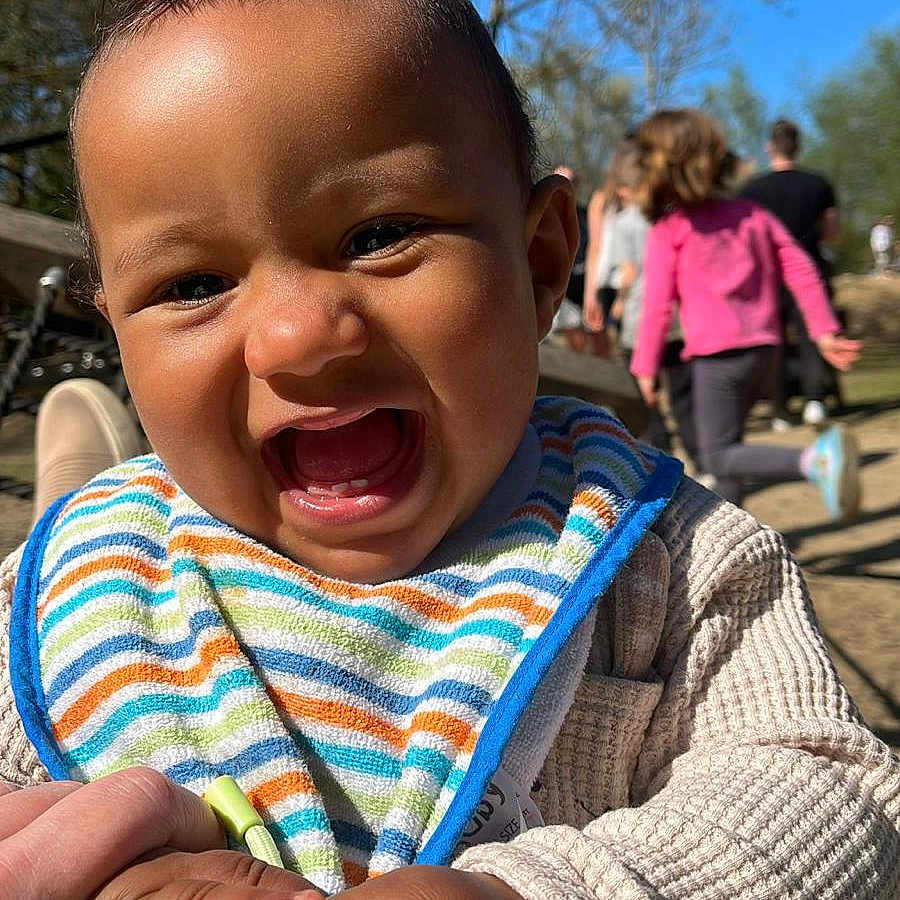 Ethan joined the competition — help win amazing prizes! adult, baby, clothing, coat, face, grass, happy, head, jacket, laughing, male, man, nature, outdoors, park, person, photography, plant, portrait, tree