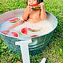 baby, bathing, bathtub, biting, bowl, eating, face, food, fruit, head, person, plant, produce, sitting, tub