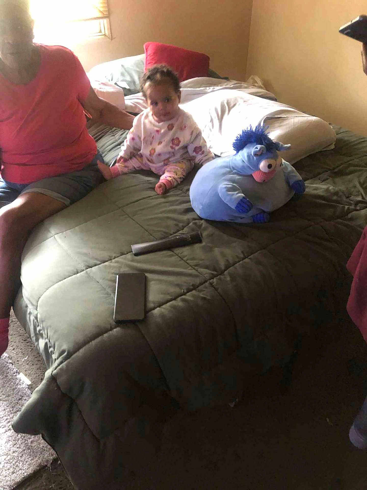 Anice joined the competition — help win amazing prizes! toddler, bed, adult, plush_toy, remote_control, smartphone, window, blanket, pillow, carpet, indoor, person, furniture, clothing, sitting, child, toy, light, room, home