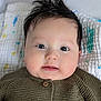 baby, infant, face, eyes, hair, knitted_sweater, button, blanket, pattern, soft_texture, closeup, portrait, cute, child, skin, cheeks, mouth, indoor, person, expression