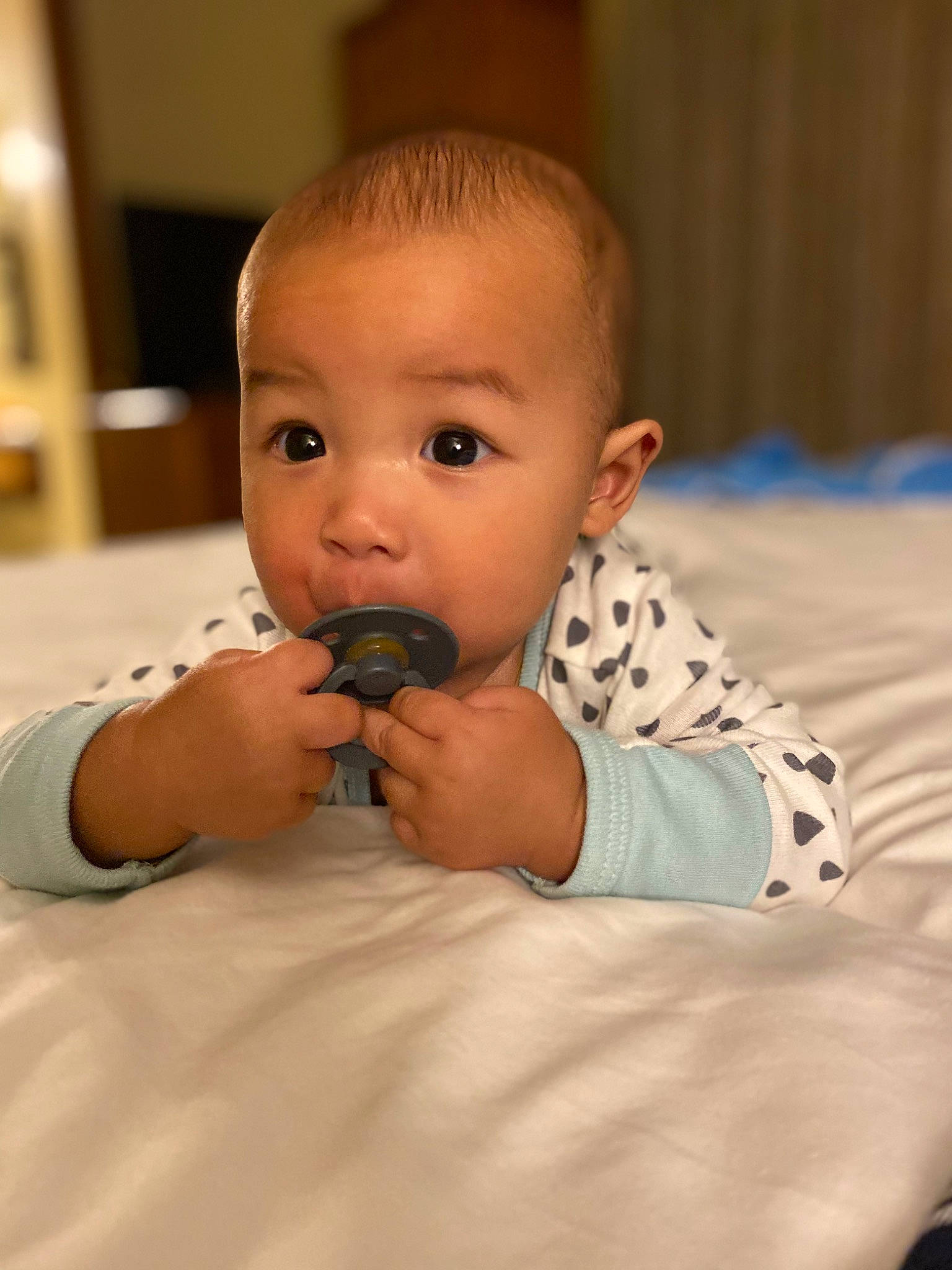 Braze is registered to the contest to win money with this photo: baby, baby_toddler_clothing, cheek, child, comfort, elbow, eyelash, flooring, fun, gesture, happy, human_body, linens, nail, nose, person, room, sitting, surprise, thumb