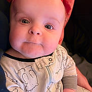 Nikolai is registered to the contest to win money with this photo: baby, child, face, onesie, clothing, hand, person, infant, cute, expression, cheeks, eyes, portrait, young, sleepwear, home, soft, comfort, holding, closeup