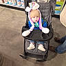 Kayden joined the competition — help win amazing prizes! baby, child, stroller, hat, pom_poms, blue_jacket, jeans, white_shoes, shopping_aisle, store, floor, adult_legs, shelf, products, pool_filters, curious_expression, indoor, person, shopping, casual