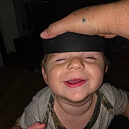 Kayden joined the competition — help win amazing prizes! child, toddler, smiling, happy, face, hand, black_band, indoor, television, animated_character, short_hair, casual_clothing, playful, skin, person, closeup, expression, light, dark_background, home