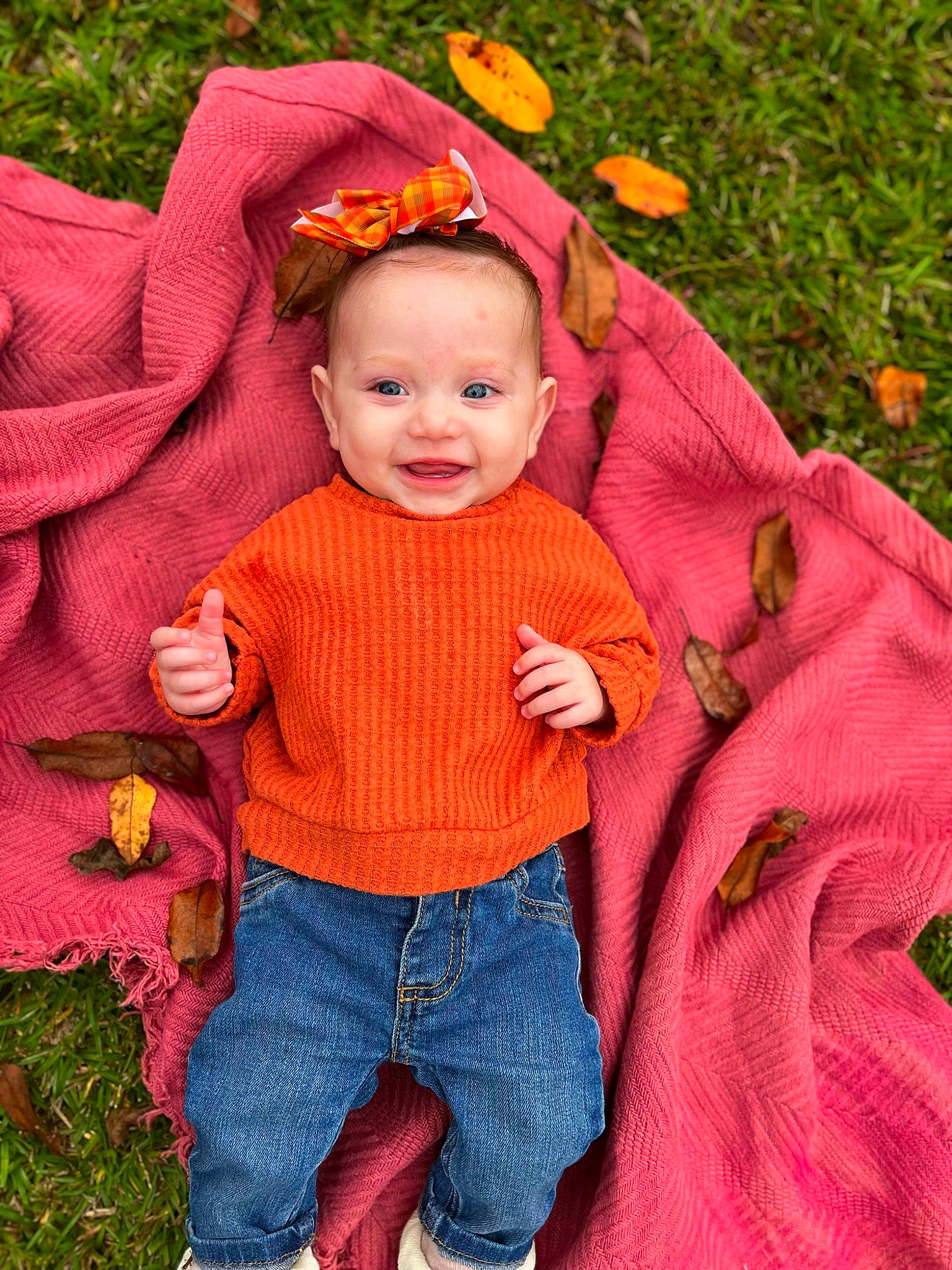 Saylah is registered to the contest to win money with this photo: baby_toddler_clothing, clothing, eye, face, facial_expression, grass, happy, head, human_body, jeans, joy, leaf, orange, outerwear, people_in_nature, person, pink, plant, sleeve, smile