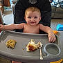 Jace Tyler Wylie is registered to the contest to win money with this photo: toddler, high_chair, food, mashed_potatoes, gravy, spoon, smiling, face, indoor, living_room, carpet, sofa, dog, child, messy, person, seat, tray, happy, casual
