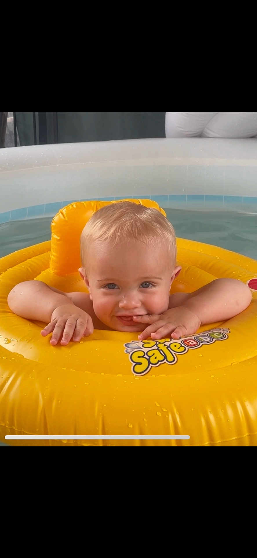 Fin joined the competition — help win amazing prizes! baby, child, pool, water, float, inflatable, yellow, blue_eyes, smiling, cute, summer, wet, playful, person, skin, face, hands, water_droplets, fun, relaxation