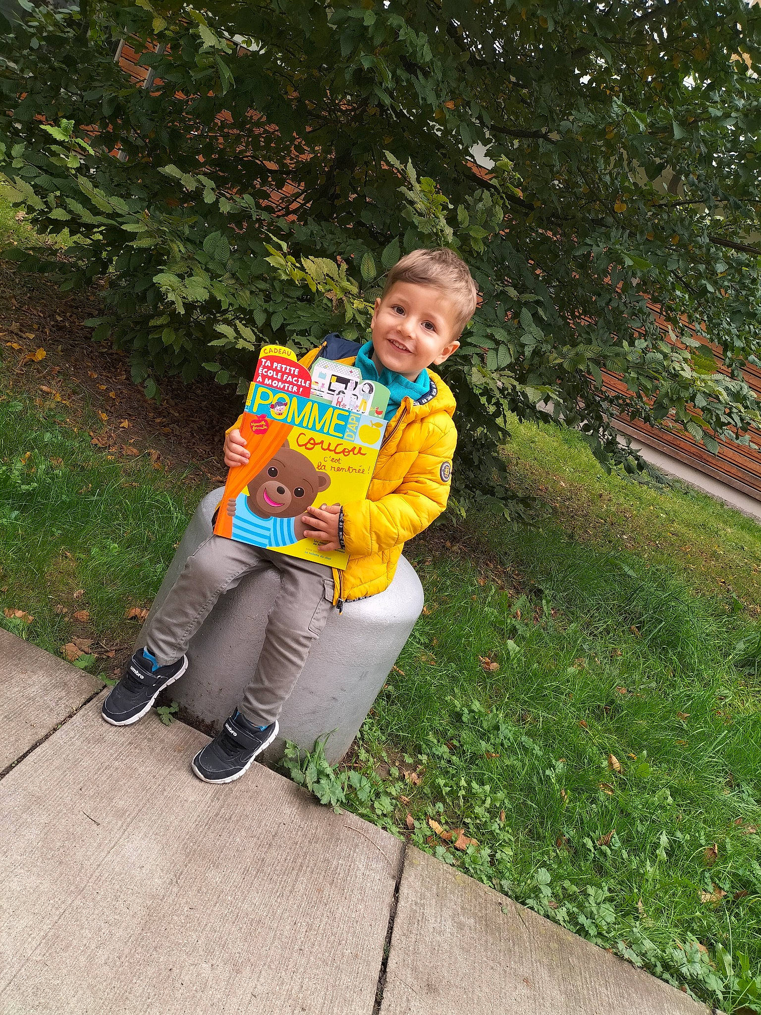 Arjin a rejoint le concours — aidez-le/la à gagner de superbes lots ! autumn, child, fun, garden, grass, grass_family, groundcover, happy, joy, leisure, people_in_nature, person, plant, recreation, shrub, sidewalk, sitting, smile, toddler, tree