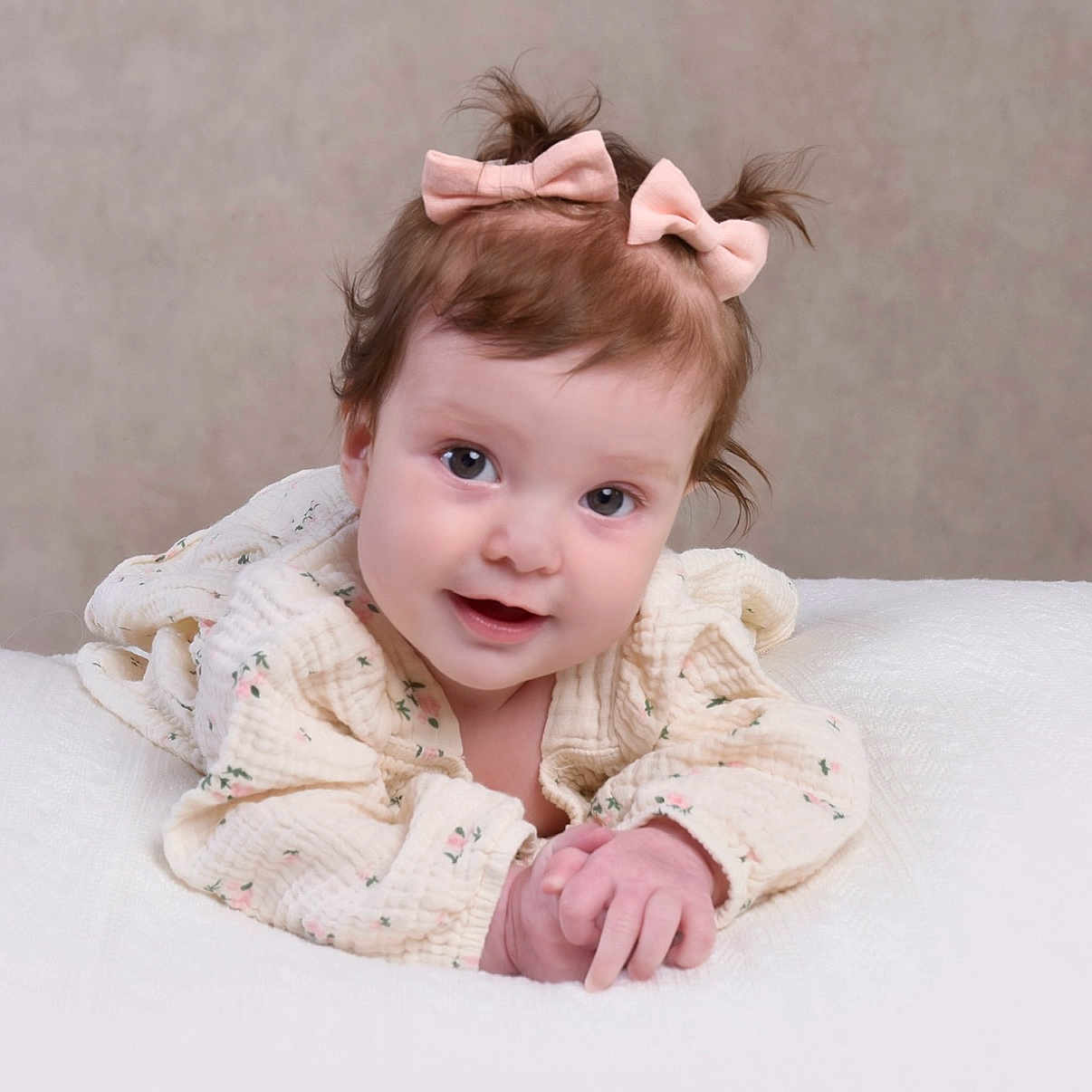 Olivia joined the competition — help win amazing prizes! baby, blanket, child, clothing, cute, eyes, face, floral_pattern, hair_bow, hands, happy, indoors, infant, lying_down, neutral_background, pink_bows, portrait, skin, smiling, soft_texture