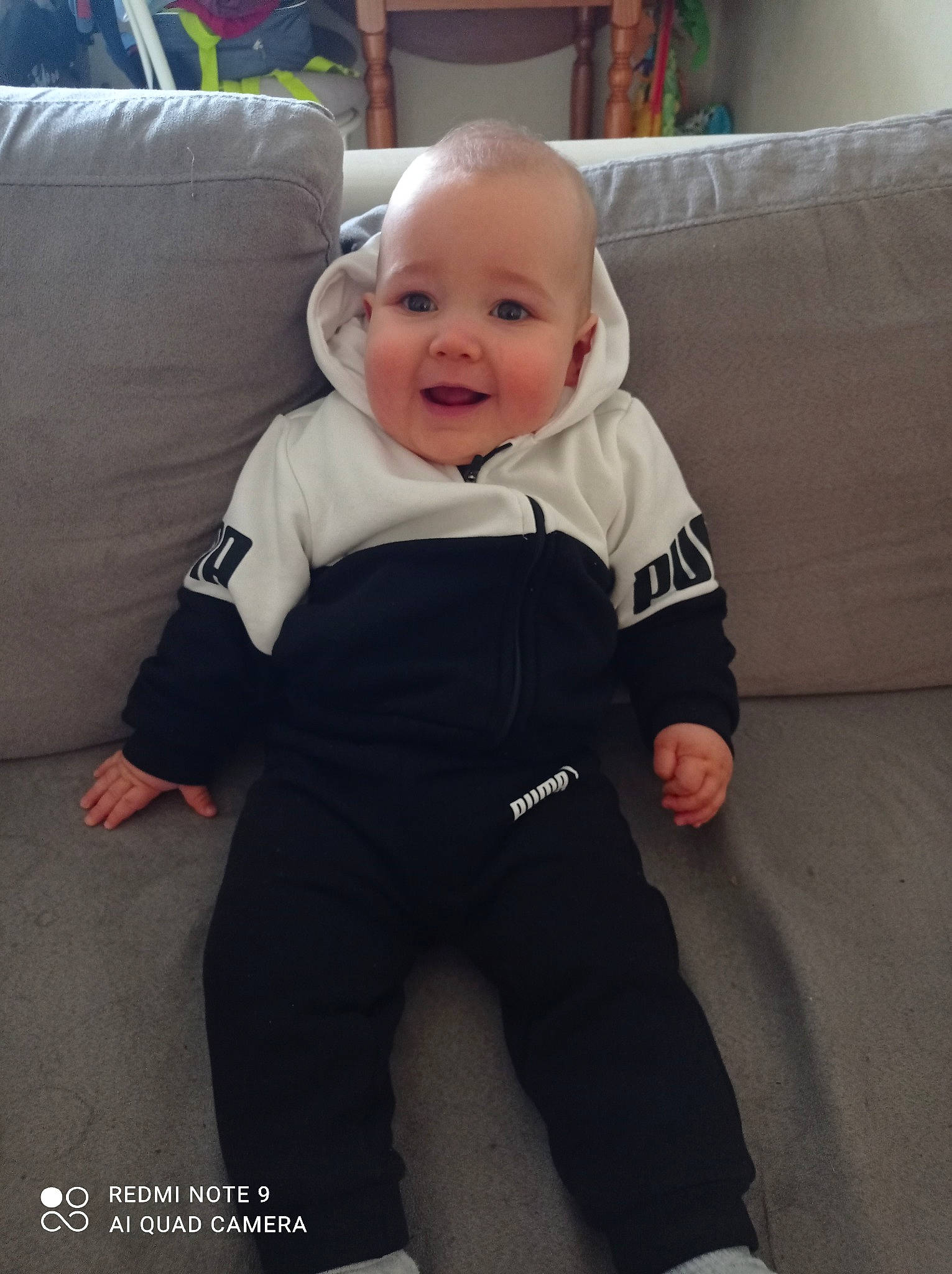 Tino participe au concours pour gagner de l'argent avec cette photo : baby, baby_toddler_clothing, child, comfort, couch, eye, flooring, happy, iris, living_room, person, picture_frame, pillow, room, sitting, skin, sleeve, smile, standing, t_shirt