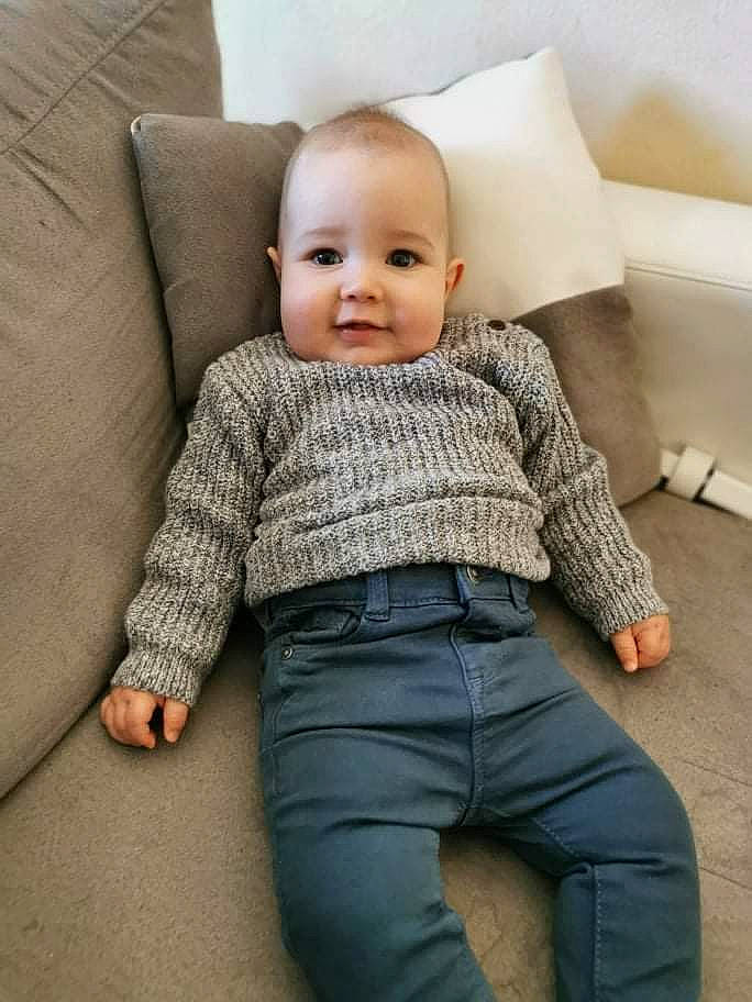 Tino participe au concours pour gagner de l'argent avec cette photo : baby, baby_toddler_clothing, collar, comfort, couch, denim, dress_shirt, eye, face, floor, flooring, happy, joy, outerwear, person, skin, sleeve, smile, t_shirt, textile