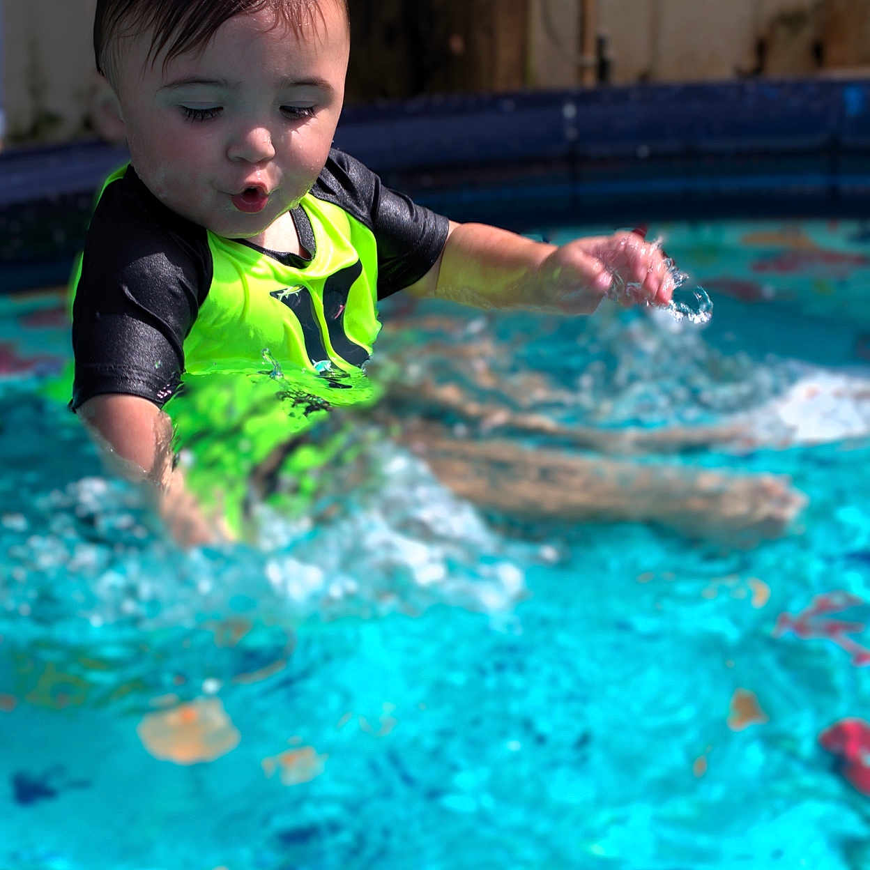Jackson is registered to the contest to win money with this photo: baby, bodypart, clothing, face, finger, hand, head, leisureactivities, lifejacket, person, photography, pool, portrait, sport, summer, swimming, swimmingpool, vest, water, watersports