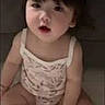 Lily is registered to the contest to win money with this photo: baby, toddler, child, sitting, clothing, bracelet, indoor, cute, face, legs, hair, skin, expression, portrait, one_person, young_child, infant, soft_surface, looking_at_camera, curious