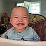 baby, high_chair, food, smile, face, indoor, child, clothing, happy, messy, light, window, door, home, furniture, seat, person, infant, expression, cute