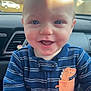 baby, child, smiling, face, blue_onesie, dinosaur_patch, car_interior, car_seat, infant, happy, cute, portrait, closeup, young_child, cheerful, indoors, clothing, person, head, eyes