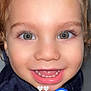 Tiago participe au concours pour gagner de l'argent avec cette photo : child, toddler, smiling, face, eyes, teeth, curly_hair, blue_heart_emoji, white_hearts, close_up, portrait, joyful, cute, young_child, happy, skin, clothing, indoor, person, expression