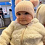 baby, blue_pillar, child, closeup, cute, face, fluffy_clothing, happy, hat, headwear, indoor, infant, jacket, people, person, pom_poms, portrait, smile, toddler, warm_clothing