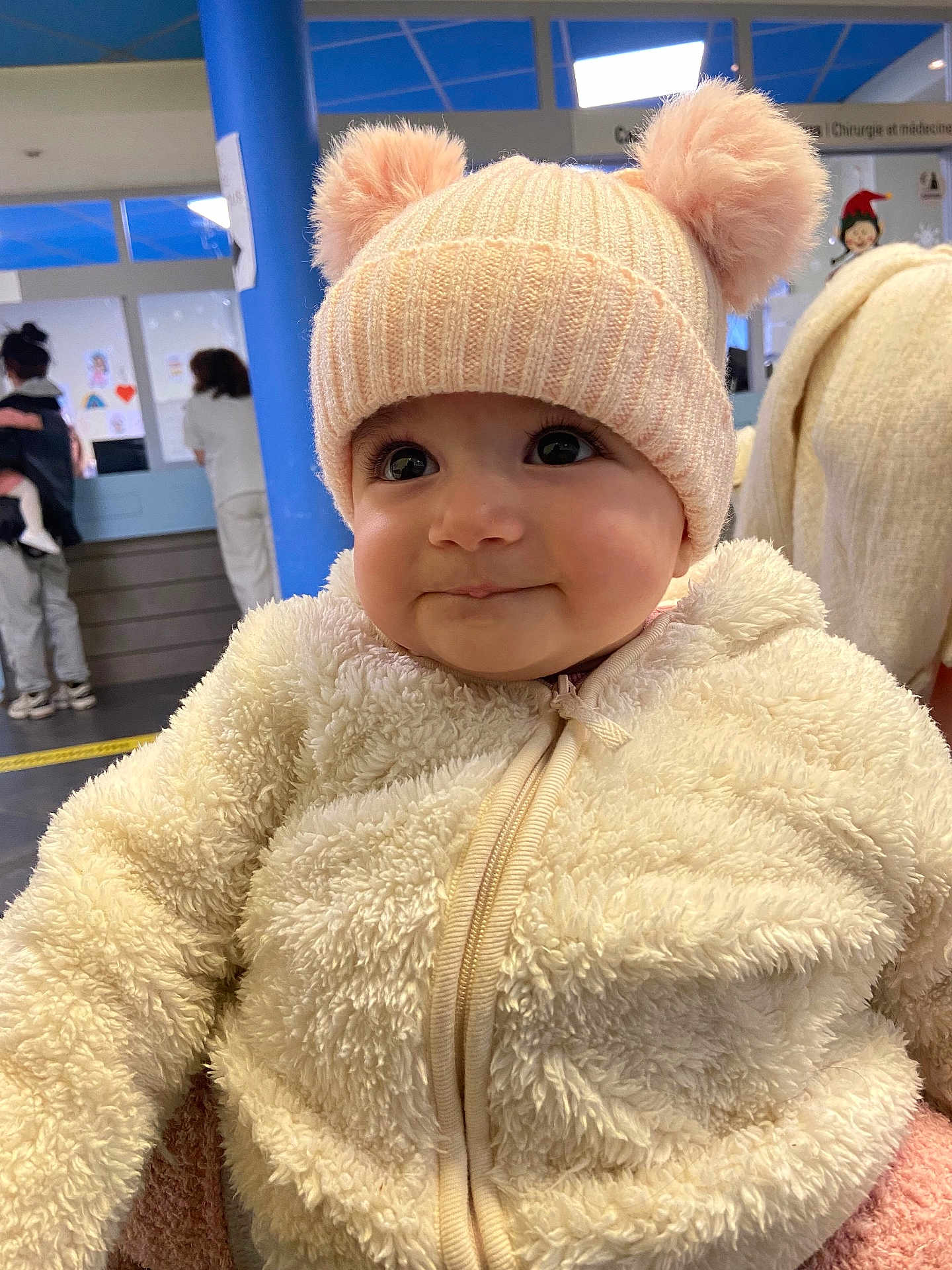 Ella Rachel participe au concours pour gagner de l'argent avec cette photo : baby, blue_pillar, child, closeup, cute, face, fluffy_clothing, happy, hat, headwear, indoor, infant, jacket, people, person, pom_poms, portrait, smile, toddler, warm_clothing