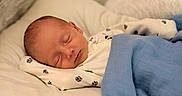 Easton is registered to the contest to win money with this photo: baby, bed, blanket, blue_blanket, child, comfort, cozy, cute, face, indoors, infant, newborn, onesie, paw_prints, peaceful, pillow, portrait, resting, sleeping, soft