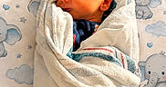 Easton is registered to the contest to win money with this photo: baby, blanket, child, closeup, cute, elephant, face, indoors, infant, newborn, pattern, peaceful, portrait, resting, skin, sleeping, soft_light, swaddled, towel, wrapped