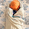 baby, blanket, child, closeup, cute, elephant, face, indoors, infant, newborn, pattern, peaceful, portrait, resting, skin, sleeping, soft_light, swaddled, towel, wrapped