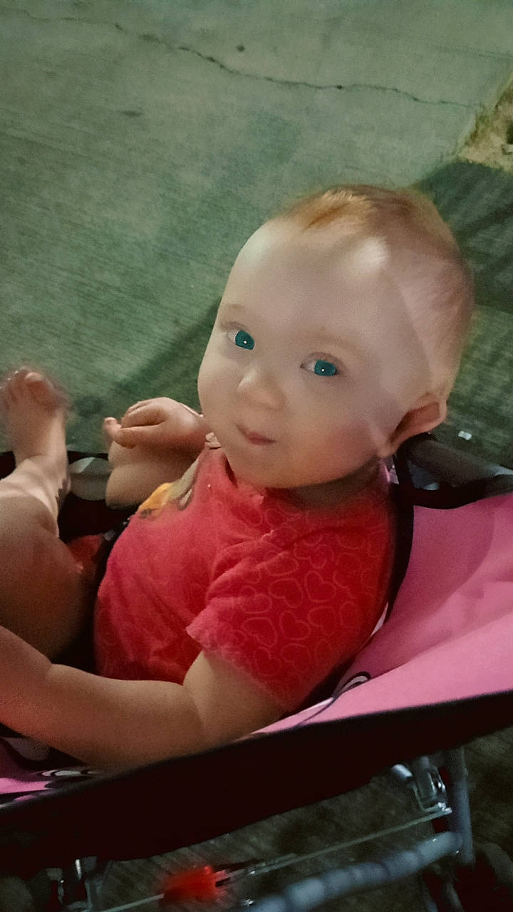 Ashley is registered to the contest to win money with this photo: arm, baby, baby_toddler_clothing, chair, cheek, child, comfort, elbow, fun, gesture, grass, hairstyle, happy, human_leg, lap, leisure, person, sitting, skin, thigh