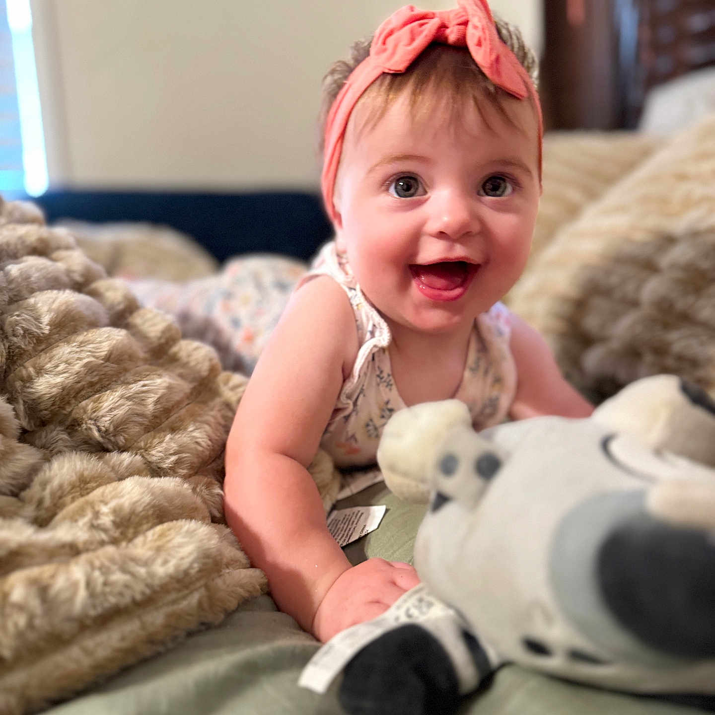 Madyx joined the competition — help win amazing prizes! baby, child, infant, smiling, happy, portrait, headband, pink_bow, bedroom, bed, blanket, stuffed_animal, plush_toy, sitting, indoors, cozy, close_up, brown_hair, floral_clothing, home