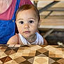 Charlie participe au concours pour gagner de l'argent avec cette photo : baby, background, child, clothing, curious, eyes, face, geometric, head, indoor, overalls, pattern, person, portrait, red_shirt, sitting, skin, table, toddler, young_child