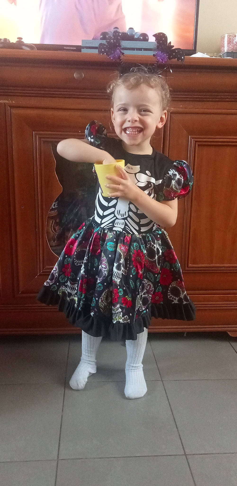 Clara participe au concours pour gagner de l'argent avec cette photo : cabinetry, door, dress, eye, flooring, hair, hand, happy, head, human_body, joy, pattern, person, plaid, shoulder, sleeve, smile, sock, tartan, toddler