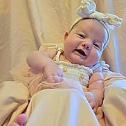 Harper is registered to the contest to win money with this photo: baby, smiling, headband, infant, cute, portrait, soft, fabric, beige, happy, child, sleepwear, toddler, skin, person, closeup, expression, indoors, cuteness, babyclothes