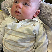 Adam is registered to the contest to win money with this photo: baby, child, face, sweater, striped, cushion, indoor, curious, seated, clothing, head, person, soft, comfort, young, infant, eyes, hand, fabric, furniture