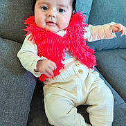 Eva participe au concours pour gagner de l'argent avec cette photo : baby, child, clothing, couch, cream_pants, cute, eyes, face, furniture, hair, hand, indoors, infant, portrait, red_scarf, sitting, smiling, socks, soft_texture, young