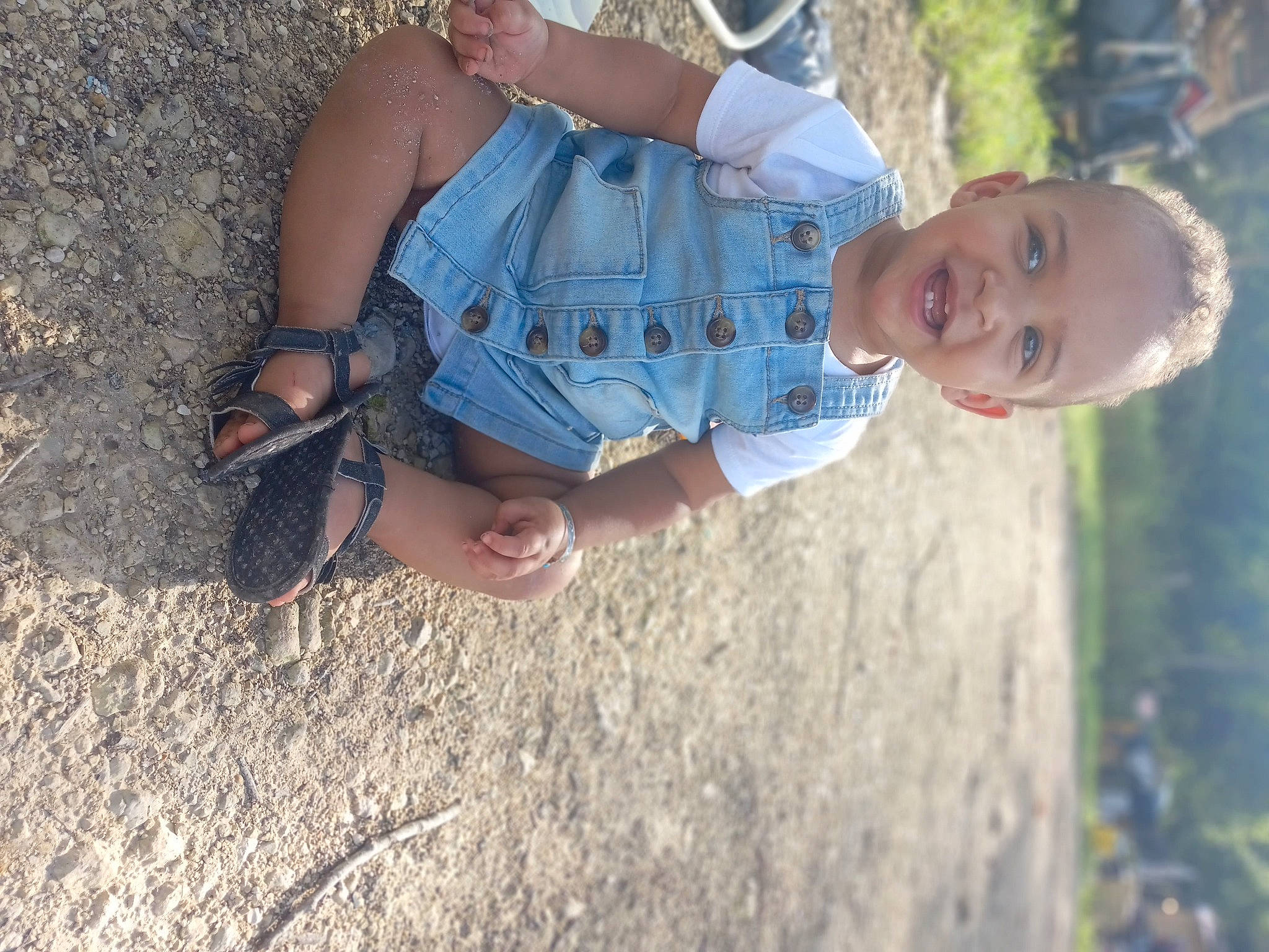 A'Kyra is registered to the contest to win money with this photo: arm, baby, child, climbing_harness, elbow, fun, gesture, grass, hand, happy, joy, leisure, people_in_nature, person, plant, recreation, sand, skin, soil, toddler