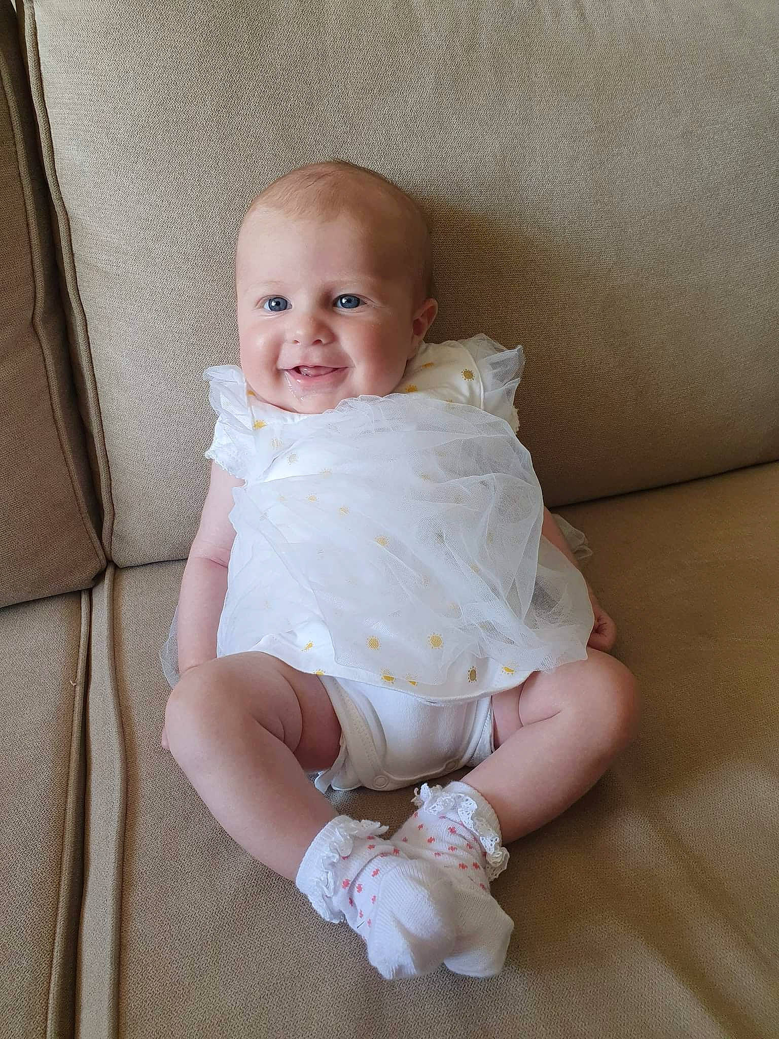 Alice participe au concours pour gagner de l'argent avec cette photo : baby, baby_toddler_clothing, blond, cheek, comfort, dress, eye, face, facial_expression, happy, head, human_body, iris, joy, knee, person, skin, sleeve, smile, standing