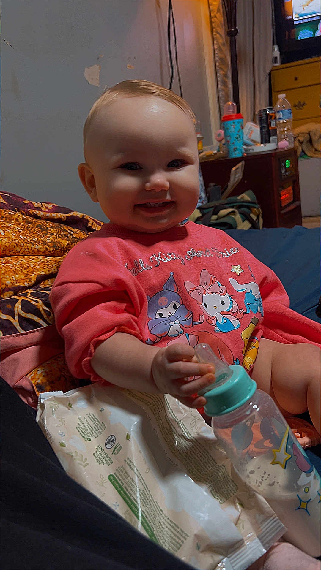 Aviahleigh is registered to the contest to win money with this photo: baby, child, infant, smile, bottle, bed, blanket, pajamas, toy, sippy_cup, room, nightstand, lamp, dresser, television, water_bottle, wipes, cute, indoors, portrait
