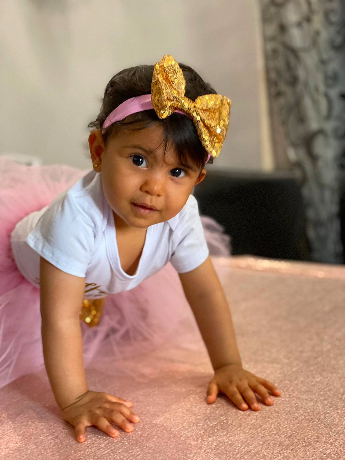 Liyana participe au concours pour gagner de l'argent avec cette photo : arm, baby, baby_toddler_clothing, child, chin, costume_hat, dress, fashion_accessory, floor, flooring, grass, happy, headband, headpiece, person, petal, sitting, skin, sleeve, toddler