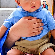 Ezekiel joined the competition — help win amazing prizes! baby, child, person, blue_shirt, khaki_shorts, socks, hand, lap, stairs, portrait, curious, indoor, holding, young_child, short_hair, cute, skin, face, seated, adult