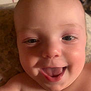 Ozzy is registered to the contest to win money with this photo: baby, face, smile, happy, child, close_up, indoor, skin, head, mouth, tongue, eyes, person, infant, cheeks, expression, young, cute, portrait, joy