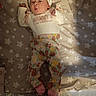 baby, bed, blanket, clothing, cute, expression, face, feet, floral, hands, headband, indoors, infant, lying_down, pajamas, pattern, pink, skin, soft_lighting, stars