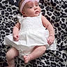 baby, blanket, child, chubby_arms, chubby_legs, curious_expression, cute, headband, indoors, infant, leopard_print, lying_down, newborn, pink_headband, portrait, resting, small_feet, small_hands, soft_skin, white_dress