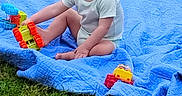 David joined the competition — help win amazing prizes! toddler, child, smile, blue_blanket, grass, outdoor, toy_truck, playing, happy, sitting, green, young_child, short_hair, casual_clothing, daylight, nature, fun, cute, person, baby