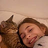 girl, child, smile, cat, tabby_cat, cuddle, bed, indoor, affection, happy, young, person, animal, pet, face, human, love, comfort, rest, casual