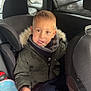 Nolann participe au concours pour gagner de l'argent avec cette photo : blanket, boy, car_interior, car_seat, casual, child, clothing, curious, headrest, indoor, jacket, lollipop, person, portrait, seat, seatbelt, toy, window, winter_clothing, young