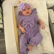 Mia a rejoint le concours — aidez-le/la à gagner de superbes lots ! baby, infant, purple_outfit, headband, flower, changing_table, diapers, tongue_out, cute, child, indoor, soft_toys, fabric, cushion, baby_care, newborn, relaxed, person, small_hands, small_feet