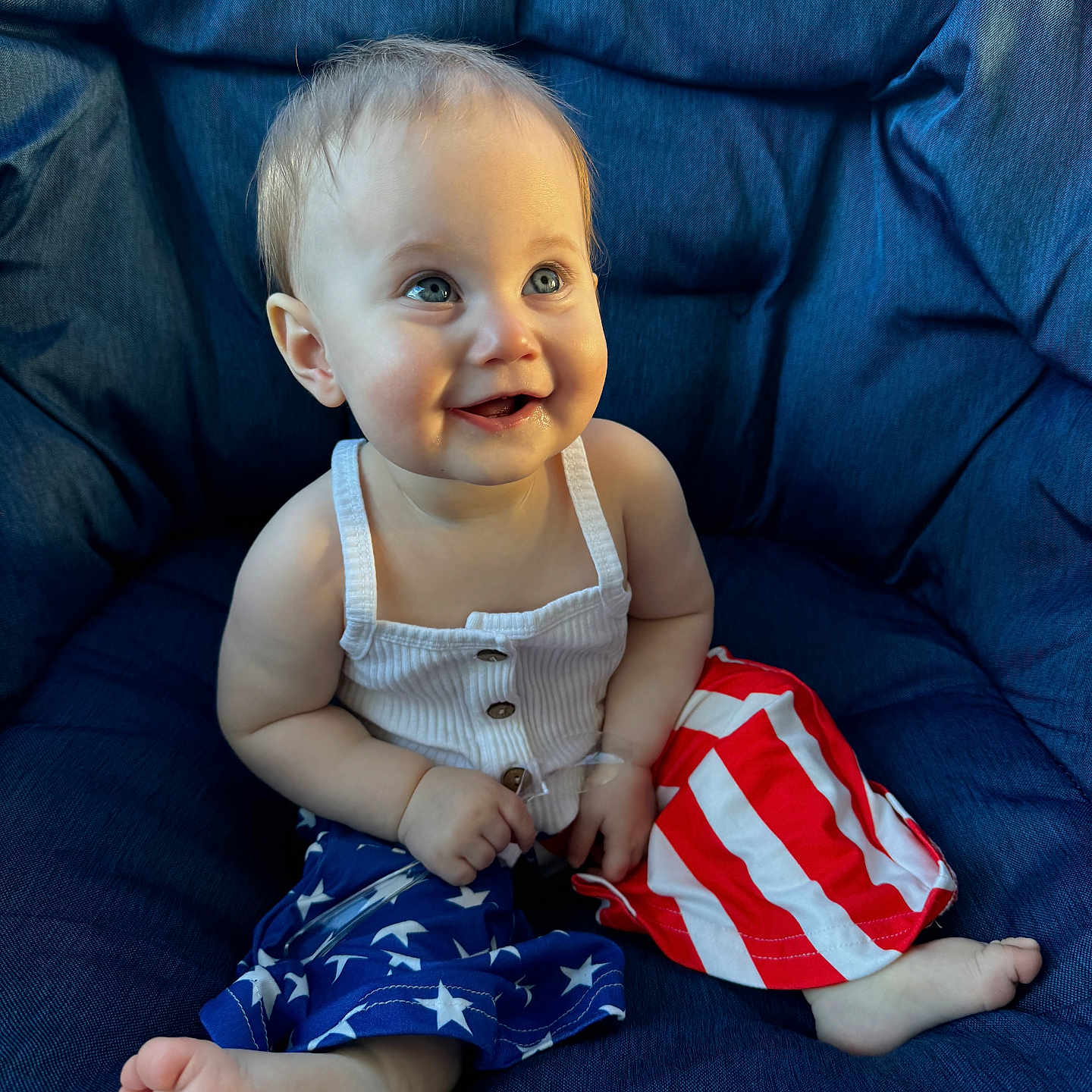 Melanie is registered to the contest to win money with this photo: baby, bodypart, clothing, couch, cushion, dress, face, finger, flag, furniture, happy, head, homedecor, pants, person, photography, portrait, shorts, sitting, smile