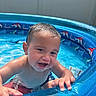 Josai is registered to the contest to win money with this photo: toddler, child, pool, water, blue, inflatable_pool, summer, wet, happy, playful, smile, baby, outdoor, splashing, skin, short_hair, fun, sunlight, hands, cute