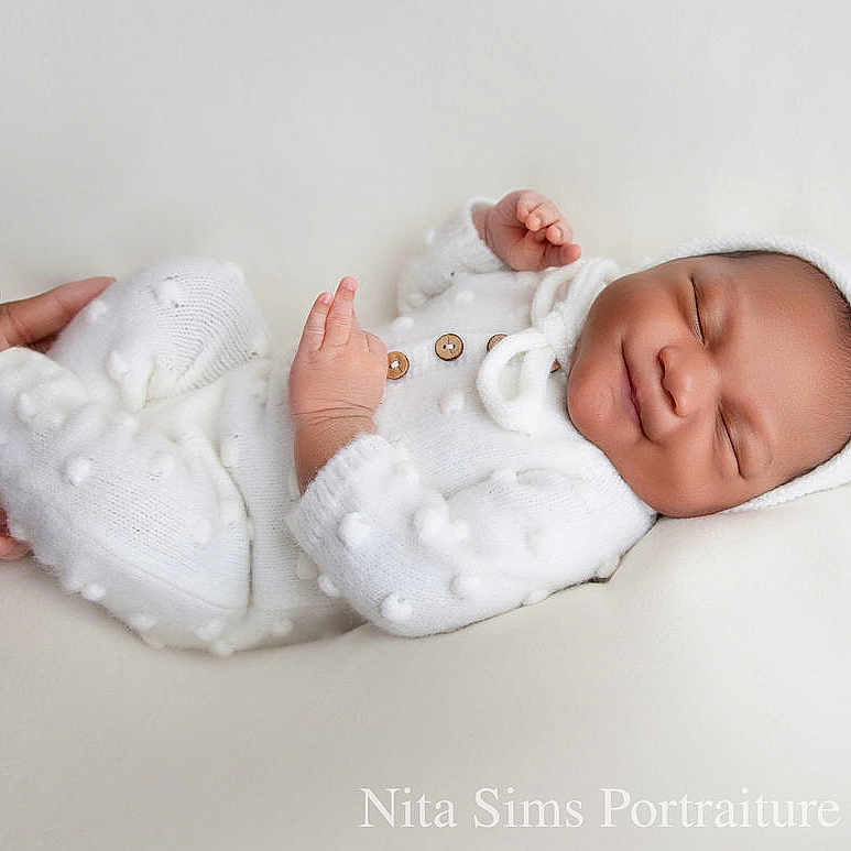 Tykarter is registered to the contest to win money with this photo: baby, bed, blanket, bodypart, bonnet, clothing, face, finger, glove, hand, happy, hat, head, newborn, pattern, person, photography, portrait, sleeping, smile