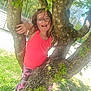 child, glasses, tree, pink_tank_top, camouflage_pants, outdoor, green_leaves, sunlight, playful, nature, grass, shoes, happy, person, summer, daylight, casual_clothing, young, fun, smiling
