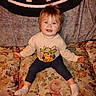 toddler, child, smiling, sweatshirt, cartoon, bunny, cowboy, couch, floral_pattern, blanket, indoor, home, socks, cute, hair, face, person, seated, happy, cozy