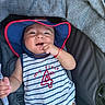 baby, child, infant, hat, sun_hat, onesie, striped_clothing, stroller, seat, happy, smiling, hand, red_string_bracelet, comfort, indoor, young_child, cute, face, person, apparel